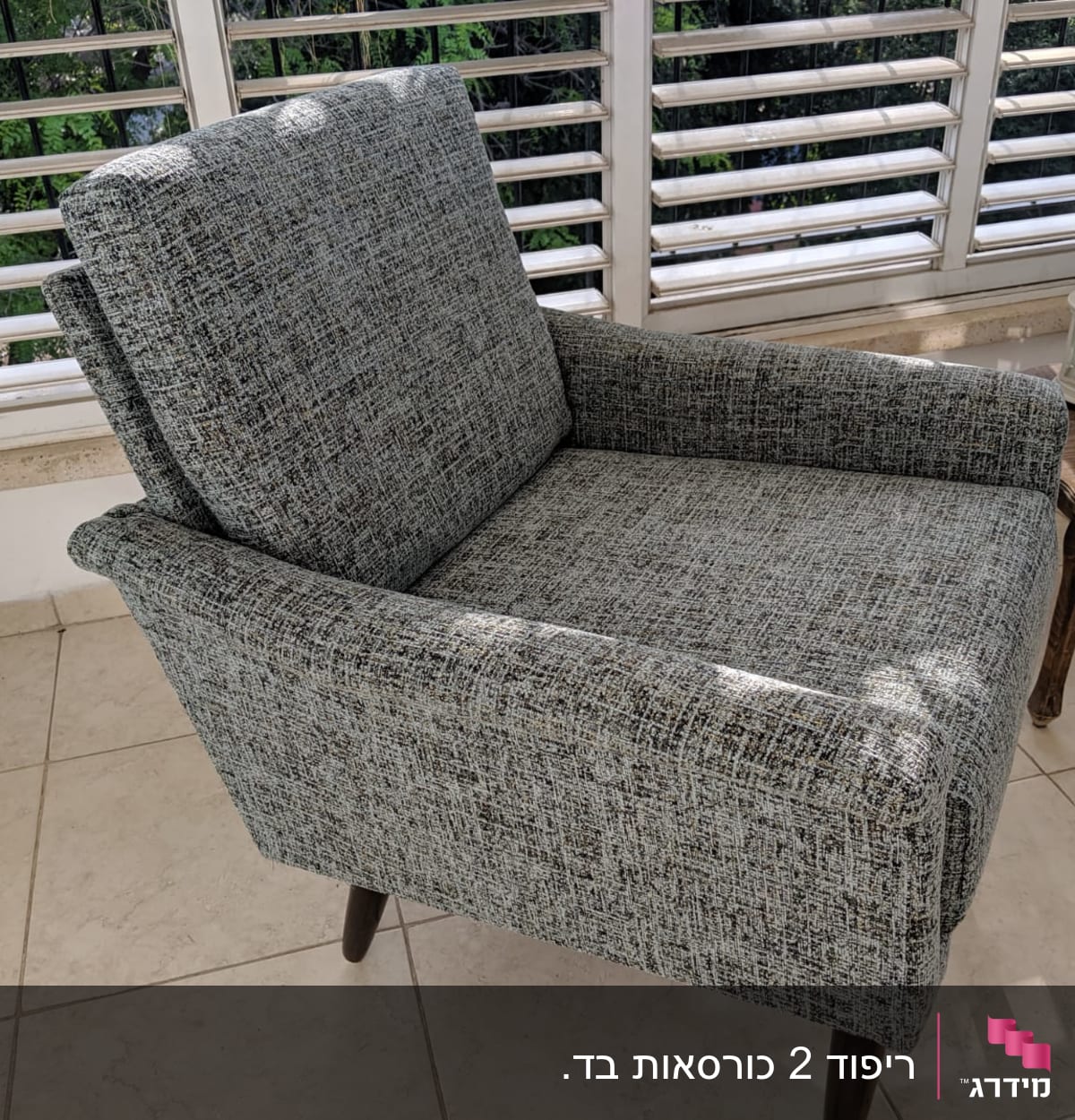 כורסה מרופדת בבד אפור עם רגלי עץ